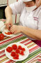 Frau wickelt Rose aus Tomatenschale