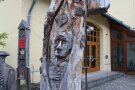 abgestorbener Baumstamm mit eingeschnitzerm Kopf, Herz und Hand