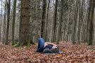 Junger Mann liegt auf einer Isomatte im Wald