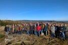 Gruppe von Menschen steht auf einer Waldkahlfläche
