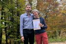 ein Mann und eine Frau mit Urkunde in der Hand