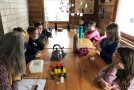 Kinder machen Pause in der Hütte, sitzen am Tisch