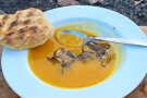 Teller gelbe Kürbissuppe mit Brot