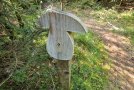 ein weißer Holzpilz auf einem Pfosten markiert den Weg