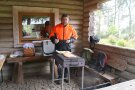 ein Mann in Forstwarnjacke steht am Grill