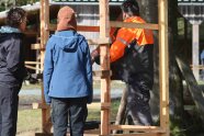 Schüler und Forstwirtschaftsmeister bauen einen Hochsitz aus Lärche