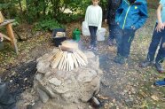 auf einem Steinsockel wird ein lagerfeuer mit kleinen hölzern vorbereitet