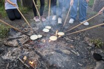Pfannen mit langem Holzstiel überm Lagerfeuer